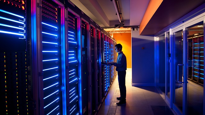 person in the server room of a large data storage centre